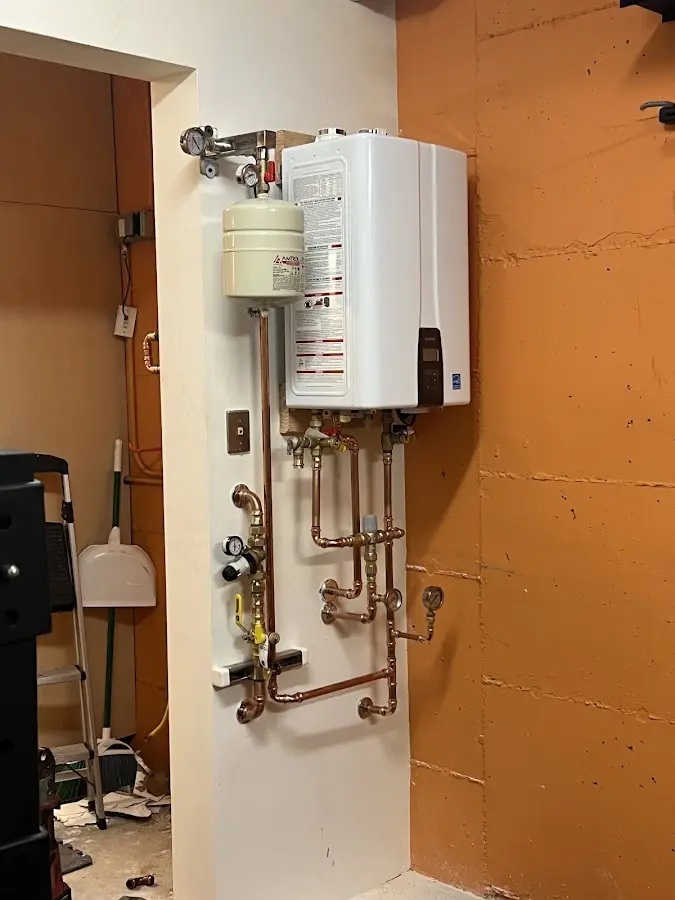 Plumbing technician inspecting water heater connections in Worcester